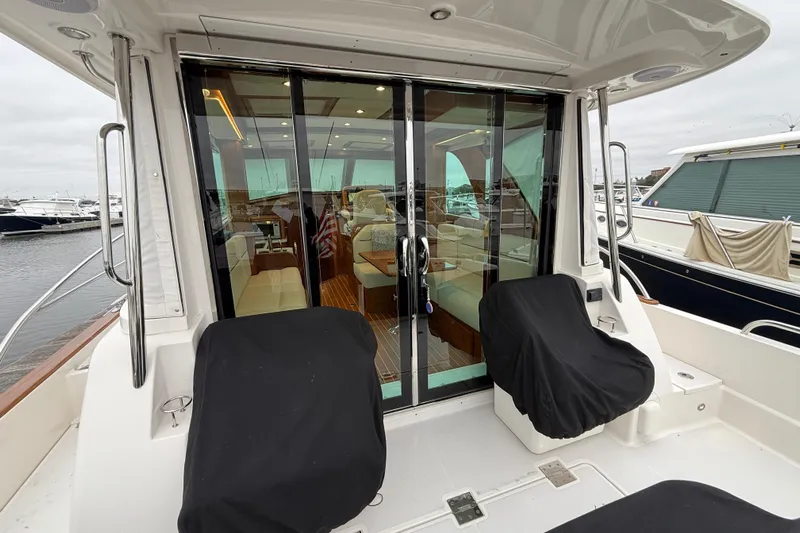Kay Lee Jean Yacht Photos Pics 2023 Sabre 43 Salon Express yacht with covered seating and glass doors at a marina.