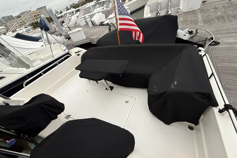 Kay Lee Jean Yacht Photos Pics 2023 Sabre 43 Salon Express yacht deck with black covers and American flag at marina.