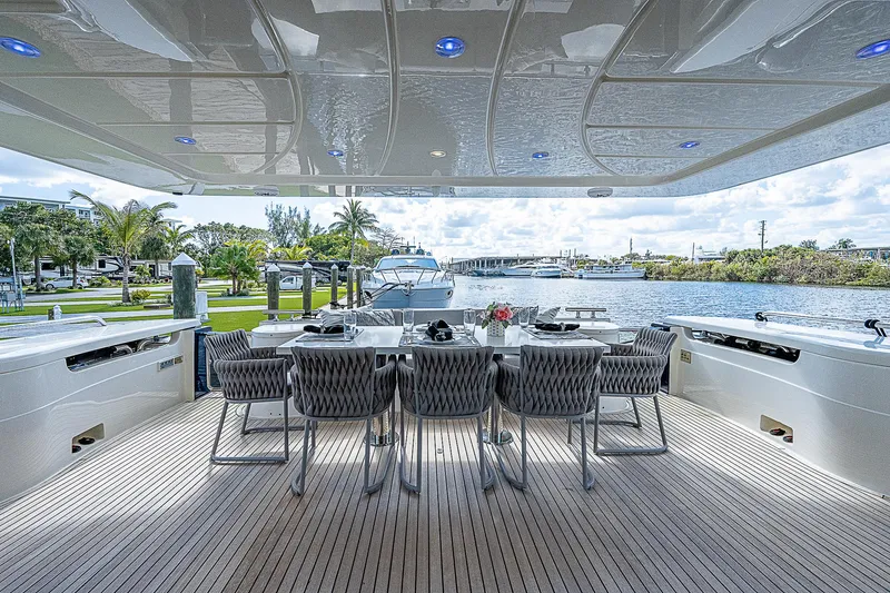 La Bella Vita Yacht Photos Pics Outdoor dining area on a 2006 Ferretti Yachts 830, overlooking a marina.