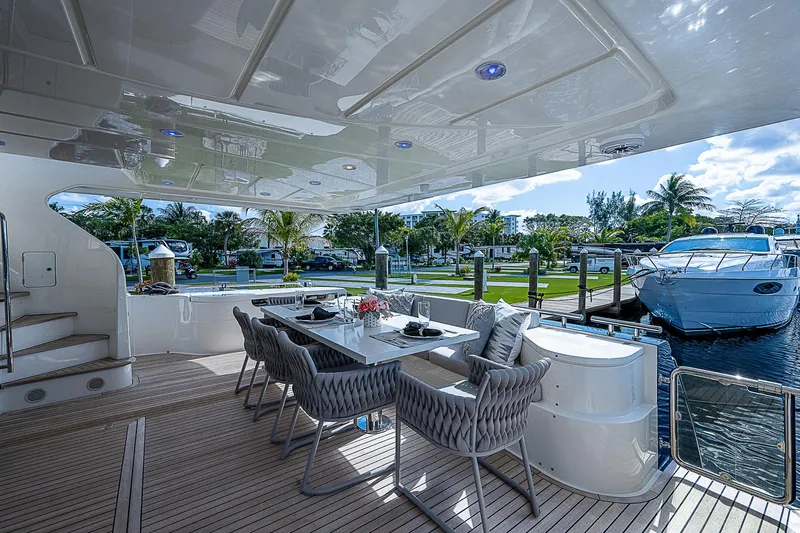La Bella Vita Yacht Photos Pics Luxurious outdoor dining area on a 2006 Ferretti Yachts 830, docked by the water.