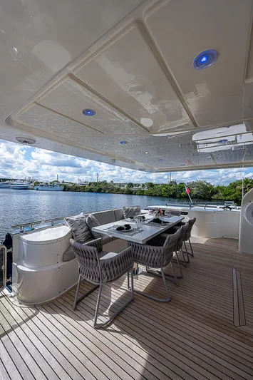 La Bella Vita Yacht Photos Pics Luxurious outdoor dining area on 2006 Ferretti Yachts 830, overlooking serene waters.