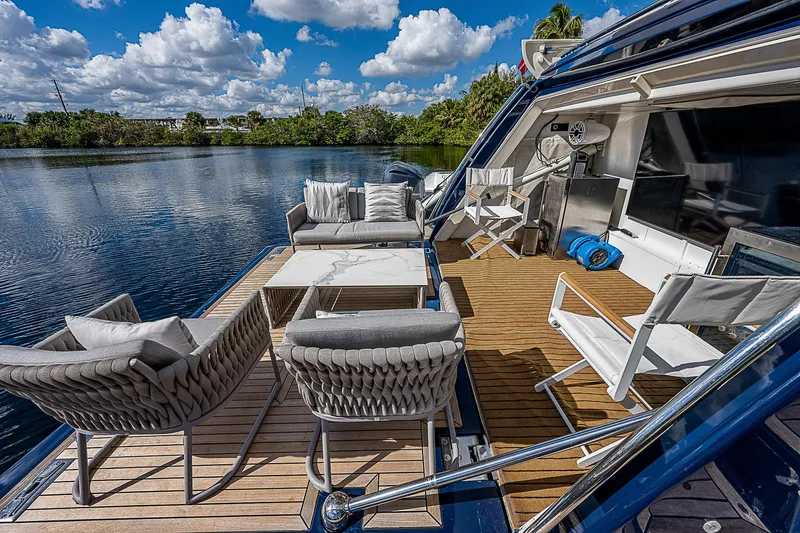 La Bella Vita Yacht Photos Pics Luxurious 2006 Ferretti Yachts 830 deck with elegant seating, overlooking serene water and lush greenery.