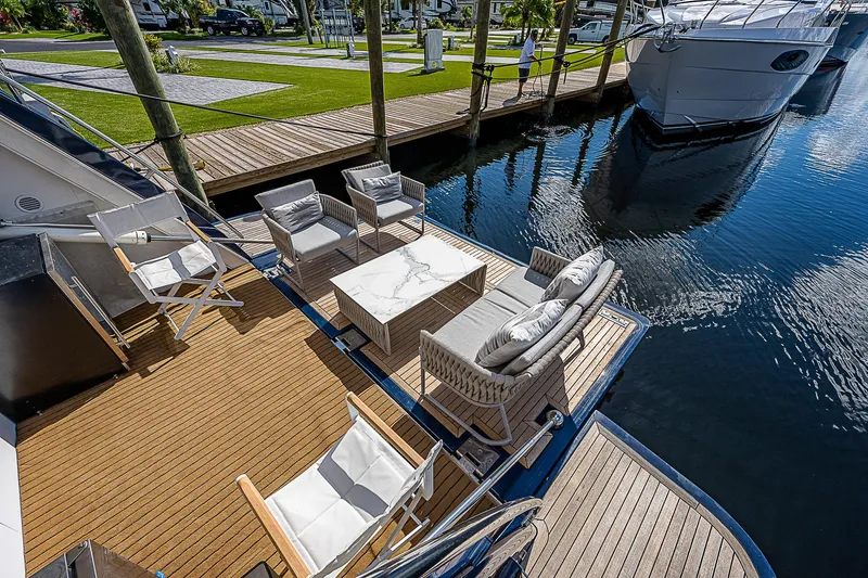 La Bella Vita Yacht Photos Pics Outdoor seating on 2006 Ferretti Yachts 830, docked by calm water.