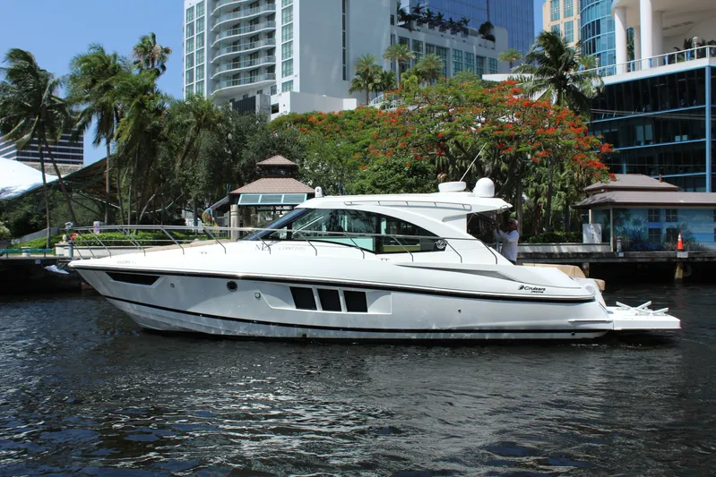 To The Moon And Back Yacht Photos Pics 2014 Cruisers Yachts 45 Cantius on a waterway with skyscrapers in the background.
