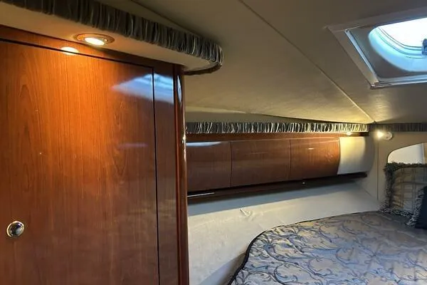  Yacht Photos Pics Interior cabin of 2003 Sea Ray 420 Sundancer with wood paneling and bed.