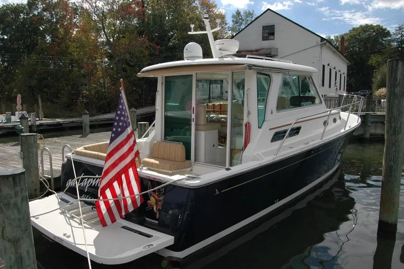 Au Lapin Agile Yacht Photos Pics 2014 Back Cove 34 boat docked, featuring American flag and elegant design.