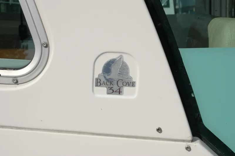 Au Lapin Agile Yacht Photos Pics 2014 Back Cove 34 boat logo on white exterior near window.