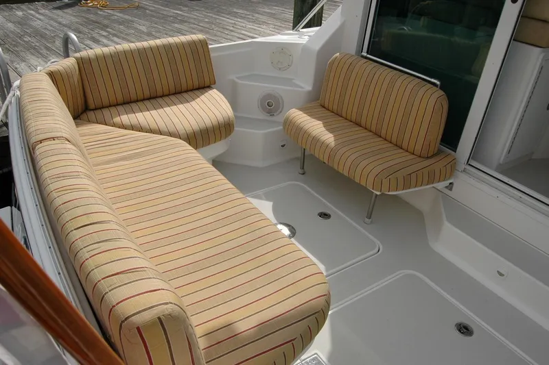 Au Lapin Agile Yacht Photos Pics 2014 Back Cove 34 boat with striped seating in the cockpit area.