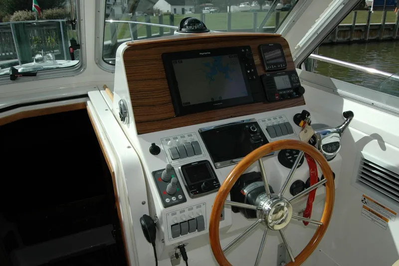 Au Lapin Agile Yacht Photos Pics 2014 Back Cove 34 helm with wooden steering wheel and navigation equipment.