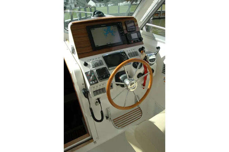 Au Lapin Agile Yacht Photos Pics Helm of 2014 Back Cove 34 boat with navigation equipment and wooden steering wheel.