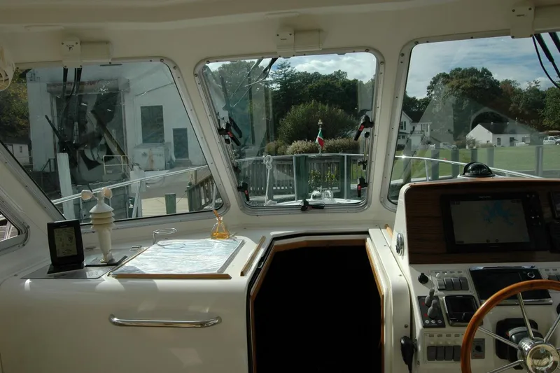 Au Lapin Agile Yacht Photos Pics 2014 Back Cove 34 yacht helm with navigation equipment and scenic marina view.