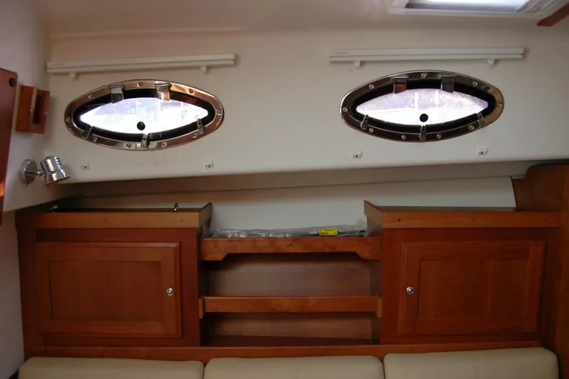 Au Lapin Agile Yacht Photos Pics Interior of 2014 Back Cove 34 boat with wooden cabinets and oval windows.