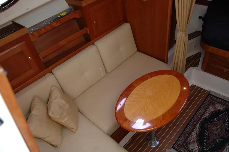 Au Lapin Agile Yacht Photos Pics Interior of 2014 Back Cove 34 yacht with beige seating and oval wooden table.