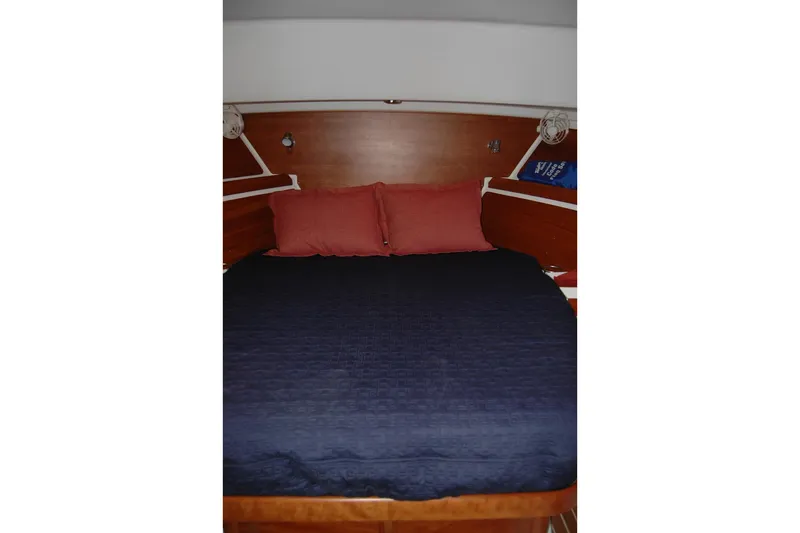 Au Lapin Agile Yacht Photos Pics Cozy cabin bed in 2014 Back Cove 34 yacht with navy bedding and red pillows.