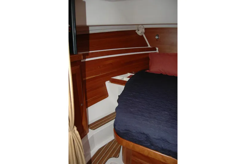 Au Lapin Agile Yacht Photos Pics Interior cabin of 2014 Back Cove 34 boat with wooden paneling and cozy bedding.
