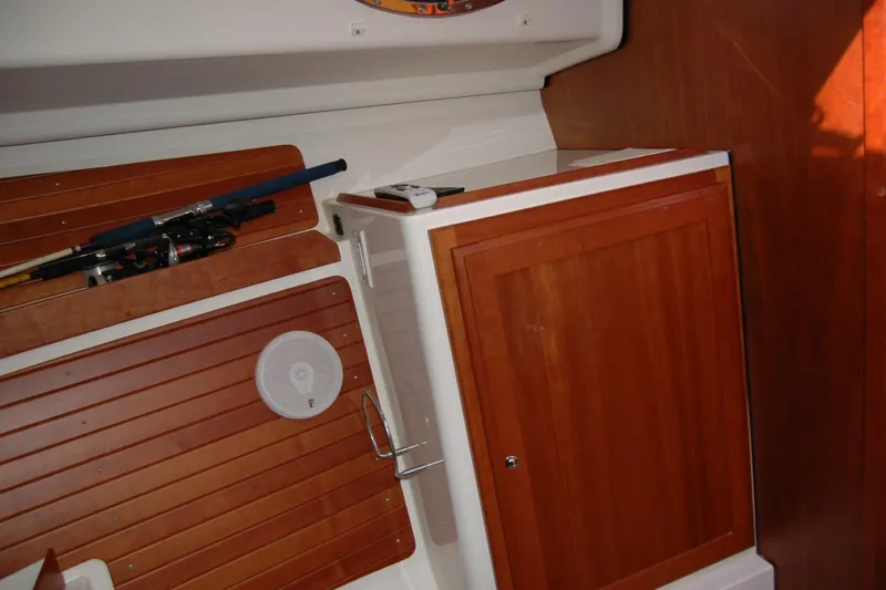 Au Lapin Agile Yacht Photos Pics Interior of 2014 Back Cove 34 boat with wooden cabinetry and fishing rods.