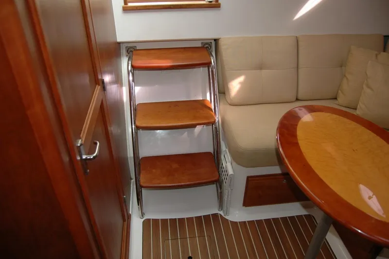 Au Lapin Agile Yacht Photos Pics Interior of 2014 Back Cove 34 yacht with wooden steps, cushioned seating, and oval table.