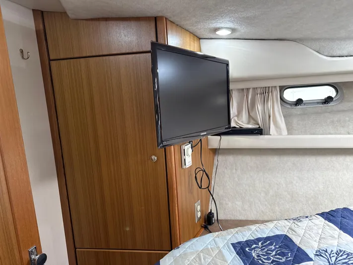  Yacht Photos Pics Interior of 2001 Bayliner 3988 yacht with TV, wood paneling, and porthole window.