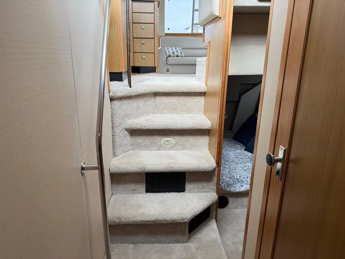  Yacht Photos Pics Interior view of 2001 Bayliner 3988 Command Bridge Motoryacht, featuring carpeted stairs and wooden cabinetry.
