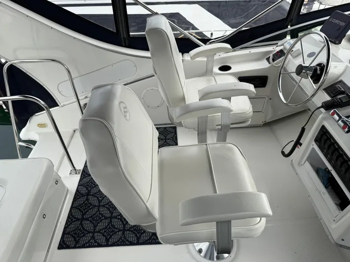  Yacht Photos Pics 2001 Bayliner 3988 Command Bridge Motoryacht helm with white captain chairs and steering wheel.