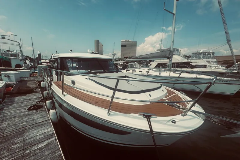 Last Tango Yacht Photos Pics Jeanneau NC 1095 boat docked at marina, 2020 model, with city skyline background.