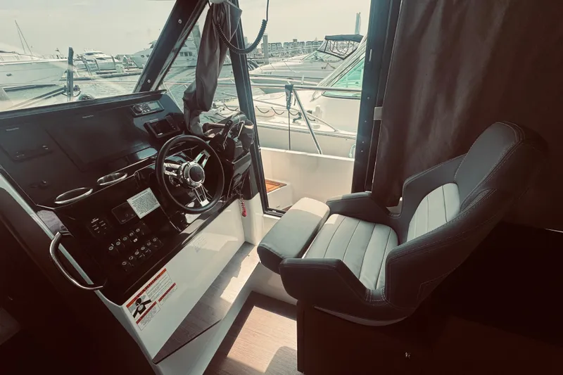 Last Tango Yacht Photos Pics Helm of 2020 Jeanneau NC 1095 boat with steering wheel and captain's chair.