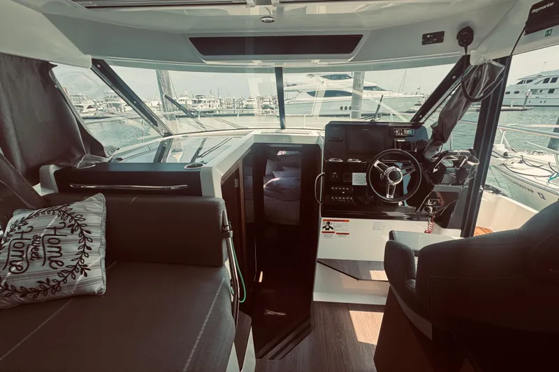 Last Tango Yacht Photos Pics Interior of 2020 Jeanneau NC 1095 boat with steering wheel and seating area.