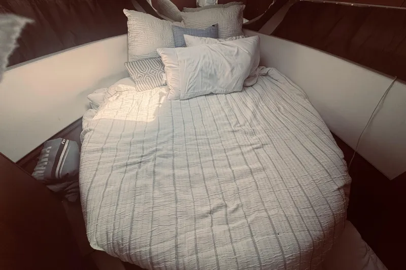 Last Tango Yacht Photos Pics Cozy cabin bed in 2020 Jeanneau NC 1095 boat, with white bedding and pillows.