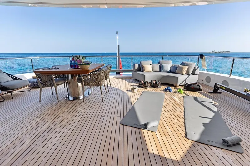  Yacht Photos Pics Luxurious 2024 Benetti Oasis 40 yacht deck with ocean view, featuring lounge and exercise area.