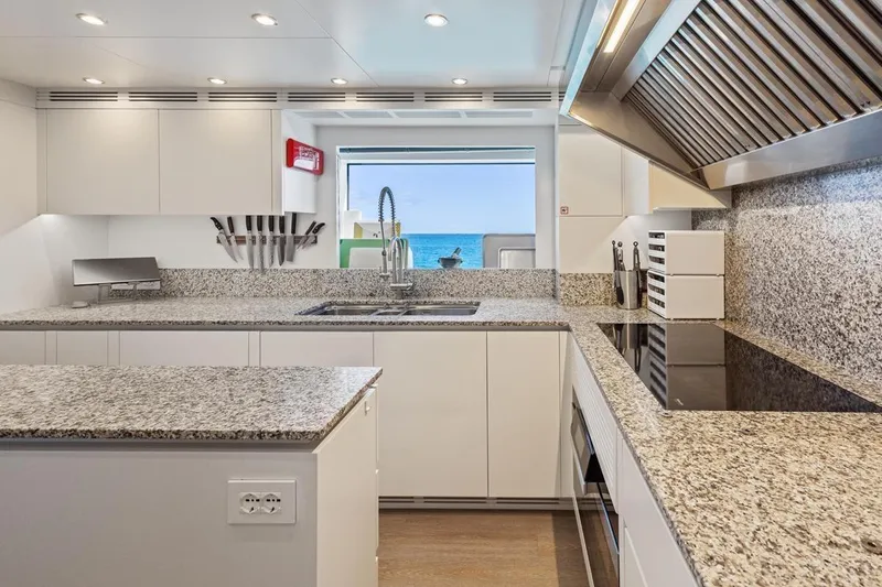  Yacht Photos Pics Modern kitchen interior on 2024 Benetti Oasis 40 yacht, featuring granite countertops and ocean view.