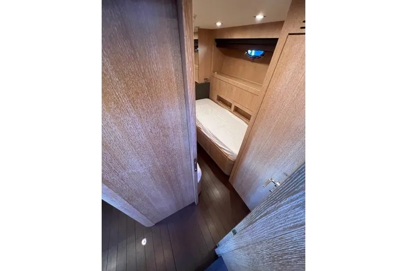  Yacht Photos Pics Interior cabin of 2009 Overmarine Mangusta 72 HT yacht, featuring wooden finishes and cozy bed.