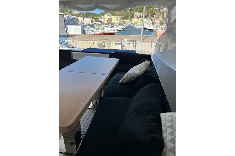  Yacht Photos Pics Luxurious seating area on 2009 Overmarine Mangusta 72 HT yacht, overlooking a scenic marina.