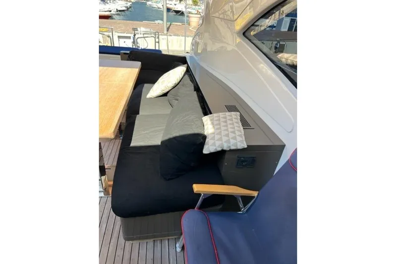  Yacht Photos Pics Luxurious seating area on 2009 Overmarine Mangusta 72 HT yacht with cushions and wooden table.