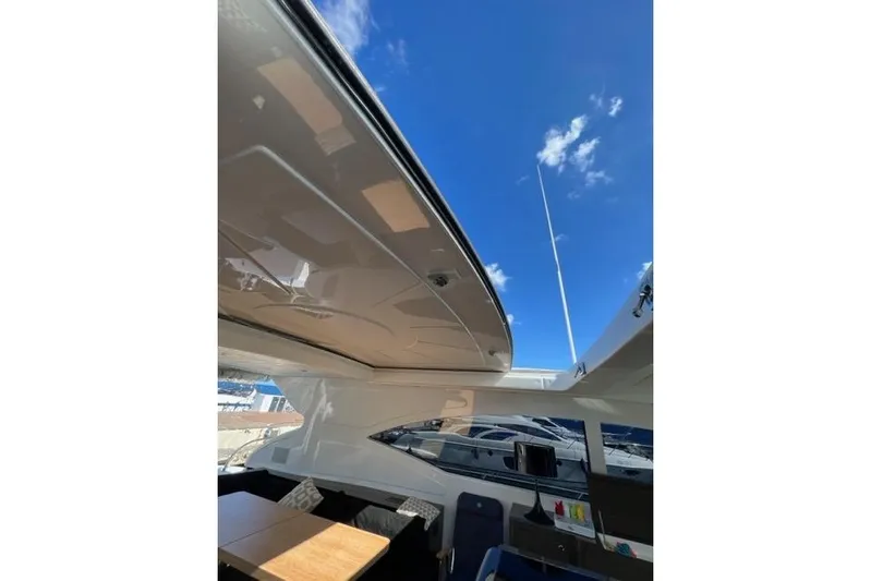  Yacht Photos Pics 2009 Overmarine Mangusta 72 HT yacht interior with open roof and blue sky view.