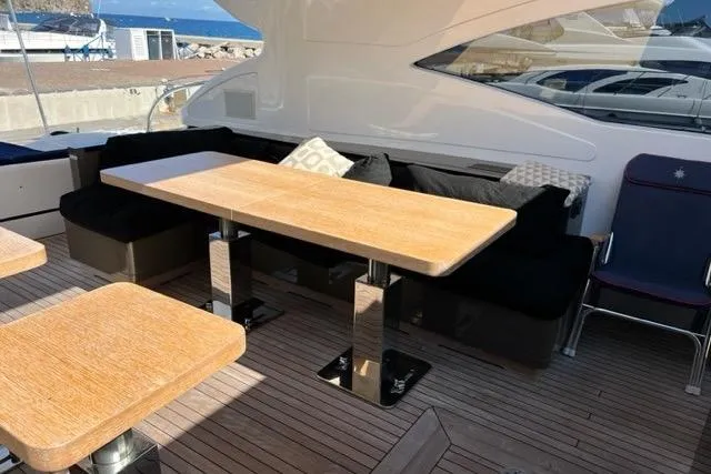  Yacht Photos Pics Luxurious 2009 Overmarine Mangusta 72 HT yacht interior with elegant wooden tables and plush seating.