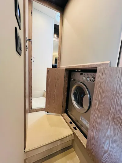  Yacht Photos Pics Laundry area inside 2022 Azimut S6F yacht, featuring a built-in washing machine.