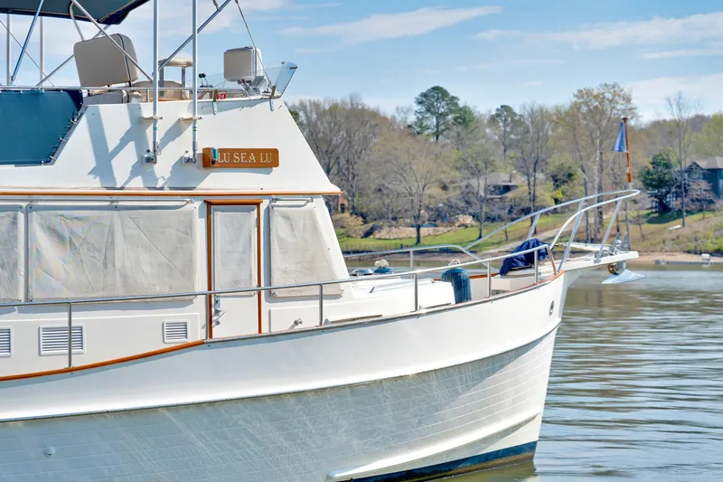 Lu-sea-lu Yacht Photos Pics 1994 Grand Banks 42 Classic yacht on calm water, surrounded by trees and clear sky.