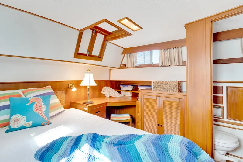 Lu-sea-lu Yacht Photos Pics Cozy bedroom in 1994 Grand Banks 42 Classic yacht with nautical decor and wooden furnishings.