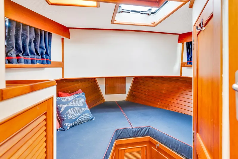 Lu-sea-lu Yacht Photos Pics Cozy cabin interior of 1994 Grand Banks 42 Classic yacht with wooden accents and blue cushions.