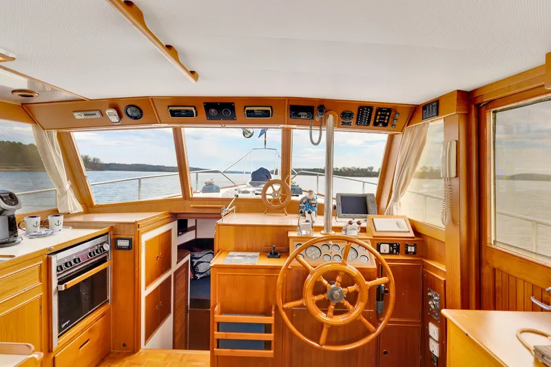 Lu-sea-lu Yacht Photos Pics 1994 Grand Banks 42 Classic yacht interior with wooden helm, navigation instruments, and scenic water view.