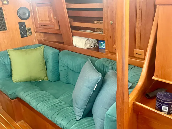  Yacht Photos Pics Cozy interior of 2001 Tartan 4100 sailboat with green cushions and wooden finish.