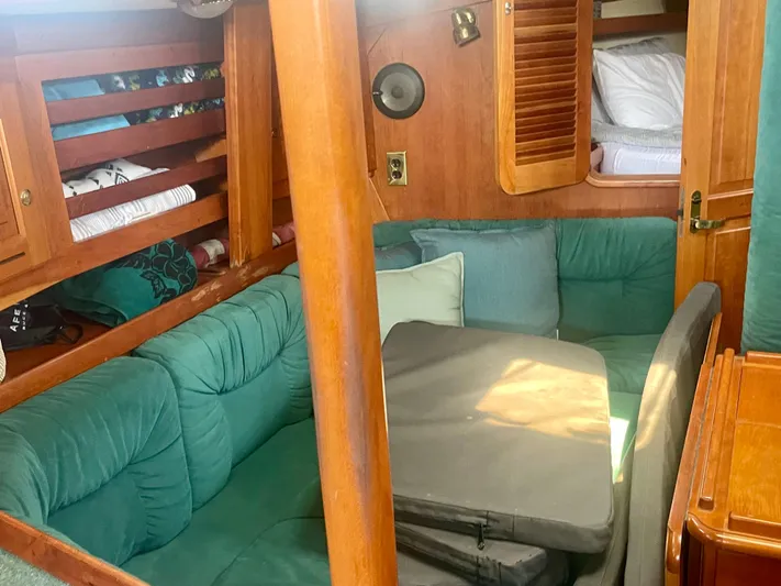  Yacht Photos Pics Cozy interior of 2001 Tartan 4100 sailboat with green cushions and wooden accents.