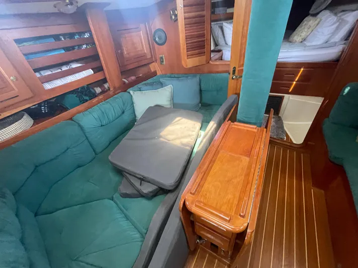  Yacht Photos Pics Interior of 2001 Tartan 4100 sailboat with green seating and wooden accents.