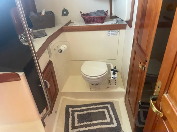  Yacht Photos Pics Compact bathroom in 2001 Tartan 4100 sailboat with wooden accents and nautical decor.