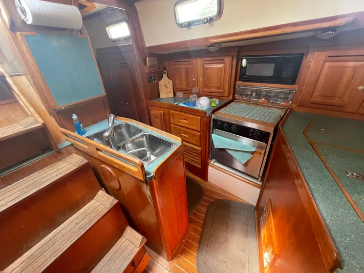  Yacht Photos Pics Interior of 2001 Tartan 4100 sailboat kitchen with wood cabinetry and modern appliances.