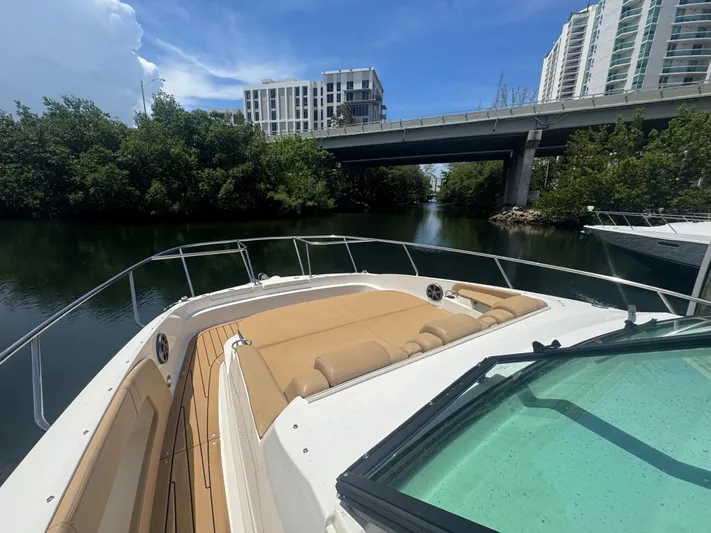  Yacht Photos Pics 2021 Sea Ray Sundancer 320 Coupe Outboard cruising under a bridge, surrounded by lush greenery.