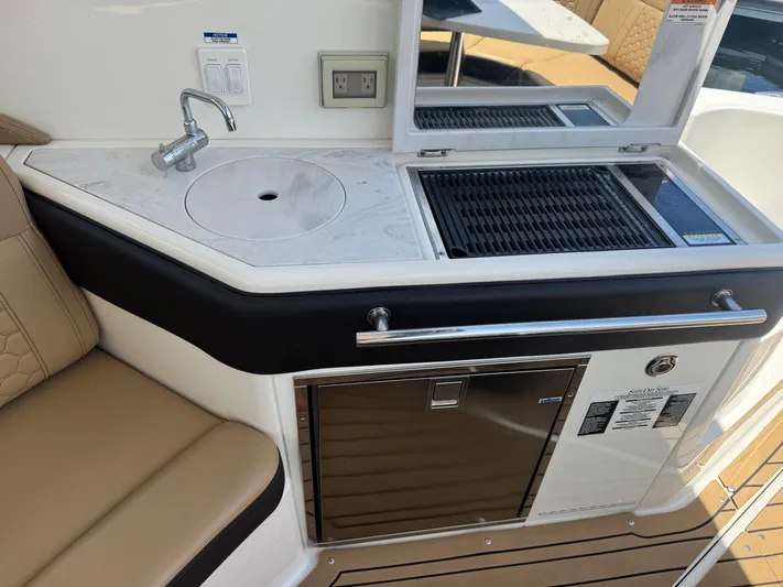  Yacht Photos Pics 2021 Sea Ray Sundancer 320 Coupe Outboard boat kitchenette with sink, grill, and seating.