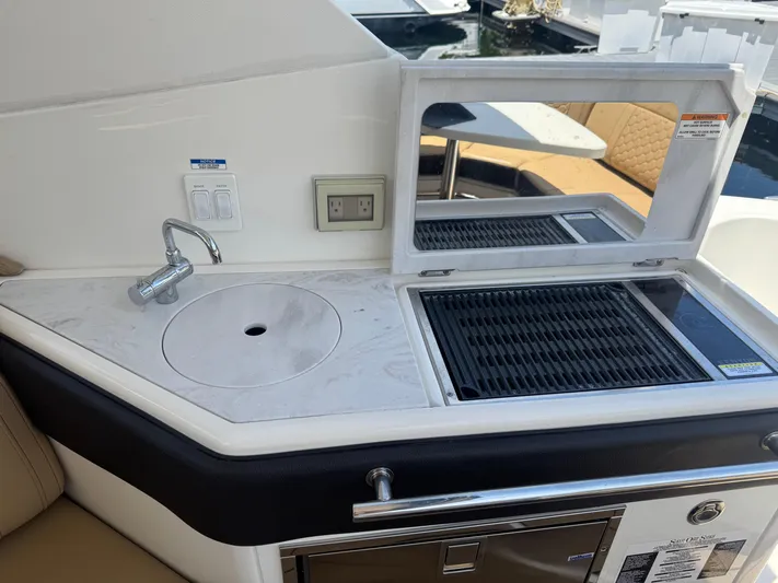  Yacht Photos Pics 2021 Sea Ray Sundancer 320 Coupe Outboard boat kitchen with sink and grill.