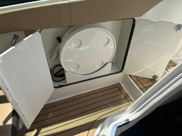  Yacht Photos Pics 2021 Sea Ray Sundancer 320 Coupe Outboard storage compartment with open doors and wooden flooring.