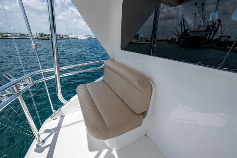 Adrian & Leidiana Yacht Photos Pics 2005 Viking 61 yacht with beige seating, overlooking a marina and cranes.